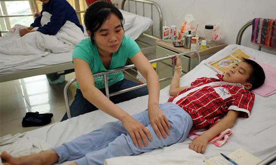 合川区合洲医院，刘峻成的妈妈正给他做按摩。重庆晨报上游新闻记者 李斌 摄